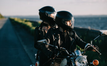 zwei Leute auf einem Motorrad in Bekleidung für Motorrad