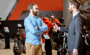 Finanzierung Motorrad zeigt einen Käufer un einen Verkäufer von einem Motorrad