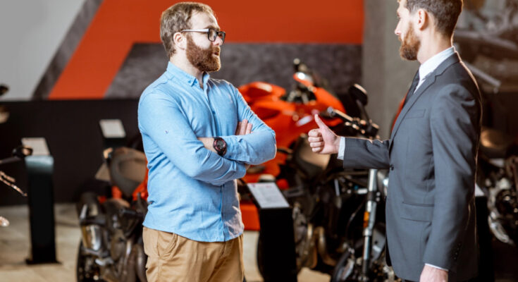 Finanzierung Motorrad zeigt einen Käufer un einen Verkäufer von einem Motorrad