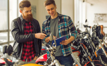 Motorradfinanzierung zeigt zwei junge Männer die sich ein Motorrad anschauen