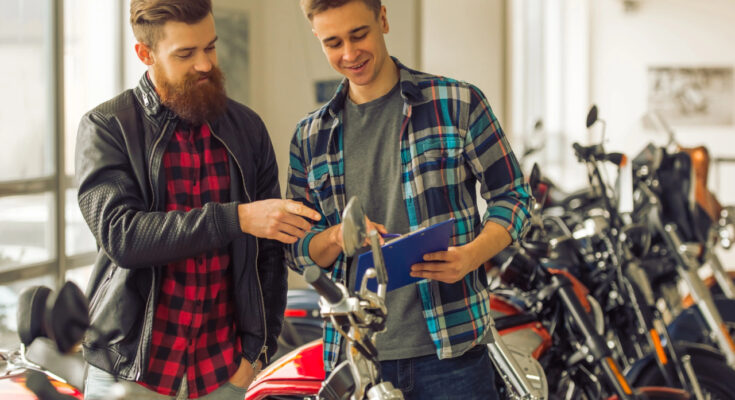 Motorradfinanzierung zeigt zwei junge Männer die sich ein Motorrad anschauen